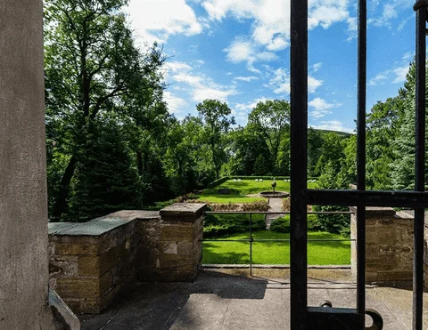 Blick durch ein Fenster auf den Schlosspark