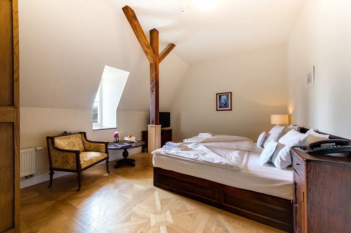 Attic room with timber beams and double bed