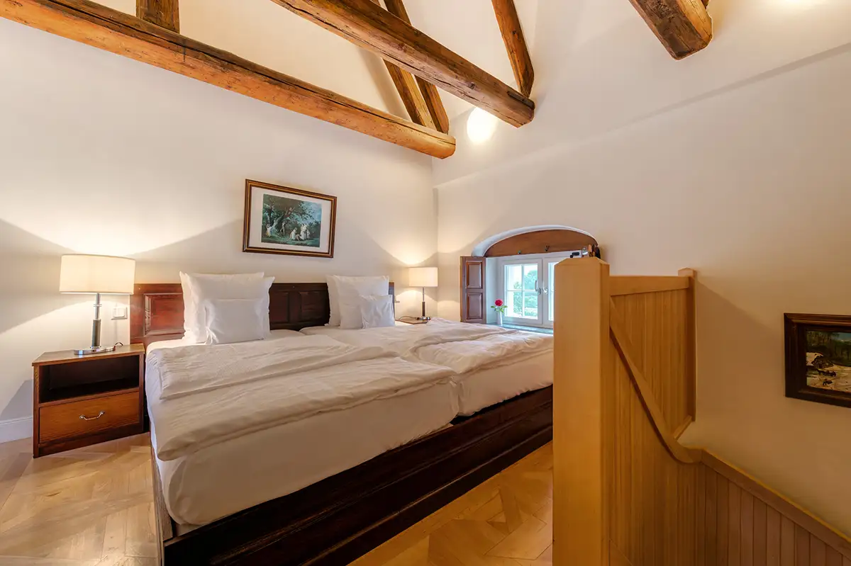 Attic room with wooden bed frame and beams