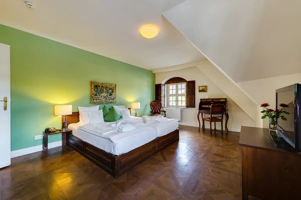 Double room with a green painted wall