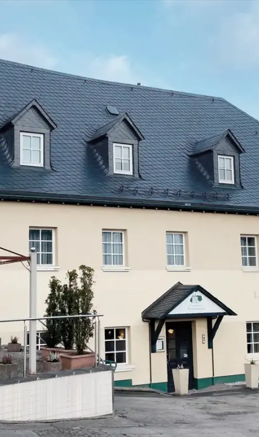 Außenansicht eines Hotels mit Terrasse und Vordach