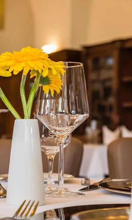 Gedeckter Tisch mit Blumen und Weingläsern im Restaurant Remise
